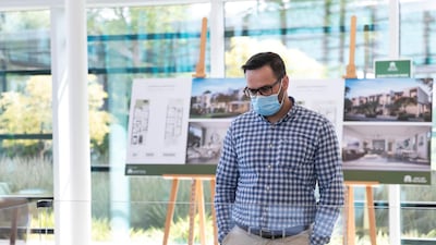 A prospective buyer looks at homes in the developer's showroom. Reem Mohammed / The National