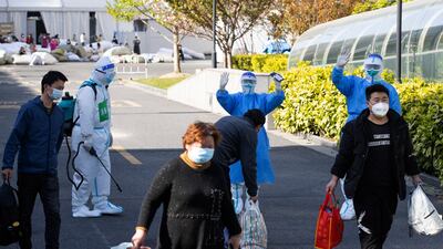 Patients who recovered from Covid-19 leave an exhibition in Shanghai that was converted into a hospital to help deal with China's biggest coronavirus outbreak. Xinhua via AP