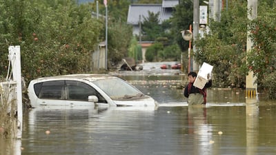A man wades through floodwaters in Nagano. AFP