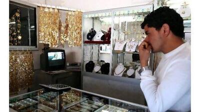 A Tunisian shopkeepers watches Libya's Muammar Qaddafi on television. Two readers suggest various ways that the GCC can help the countries of North Africa. Jim Hollander / EPA