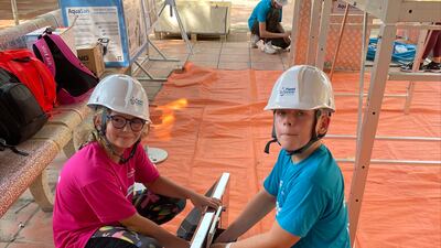 Roan Gillespie, 11, and his sister Fern, 10, help to build a water tank in Hanoi. Photo: Jennifer Gillespie