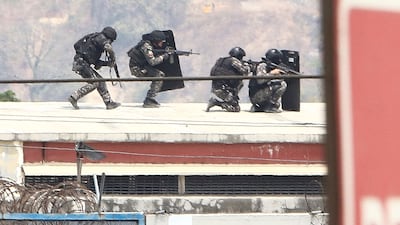 Members of the elite police take up position on the roof of the Guayas 1 prison during an operative to control a riot in Guayaquil, Ecuador. AFP