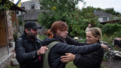 Maria, centre, hugs her parents Marina and Alexander during their first meeting after seven months since the beginning of the war in the recently retaken town of Izium, Ukraine. AP