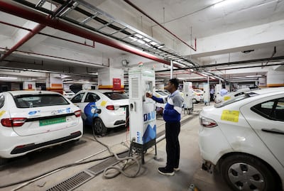 A man charges an electric vehicle in Gurugram, India, in December 2022. Reuters