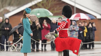 Catherine, Princess of Wales meets Irish wolfhound Seamus and his handler, Drummer Adam Walsh, on a visit to the 1st Battalion Irish Guards for the St Patrick's Day Parade, at Mons Barracks in Aldershot. PA