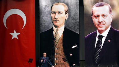 Turkey's Prime Minister Recep Tayyip Erdogan addresses members of his ruling AK Party, as he stands in front of portraits of himself and Mustafa Kemal Ataturk, left, the founder of modern Turkey, during a meeting at his party headquarters in Ankara. Adem Altan / AFP