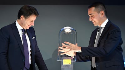 Italian labour and industry minister Luigi Di Maio, right, and Prime Minister Giuseppe Conte, left, unveil the country's first citizenship wage card this month. Jobseekers will be offered three jobs before losing their rate to the wage. Alberto Pizzoli / AFP