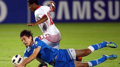 Temurkhuja Abdukholiqov, left, hit the turf, but he and his Uzbekistan teammates didn't fall to Mohamed Fawzi and the UAE on Wednesday night.