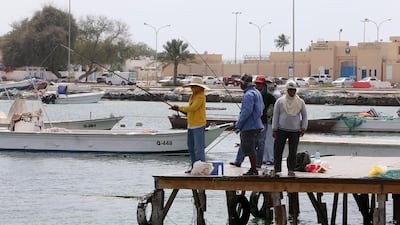 Sharjah resident Eusebio Fernandez, in the yellow shirt, fishes in Umm Al Quwain with friends. Pawan Singh / The National