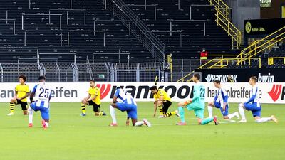 Both teams drop to one knee for a moment's silence shortly before kick-off in support of the Black Lives Matter protests. AP