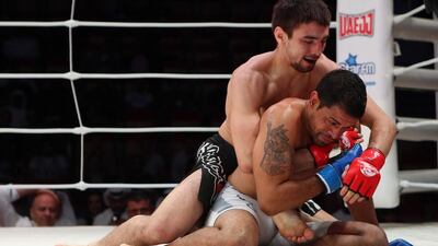 Jason Santana, of the US, in white shorts, fights with Pavel Gordeev from Russia in the Abu Dhabi Warriors 4 at IPIC Arena in Zayed Sports city in Abu Dhabi. Ravindranath K / The National