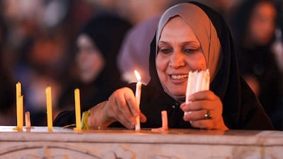 A woman lights candles at the Sheikh Abdul Qadir Al Jilani Shrine in Baghdad, Iraq. AFP