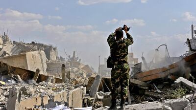 A Syrian soldier inspects the wreckage of part of the Scientific Studies and Research Centre (SSRC) compound north of Damascus, which was targeted by US-led strikes. Louai Beshara / AFP