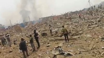 People gather where buildings once stood after a blast caused by a crash between a truck carrying explosives and a motorcycle occurred near the city of Bogoso, Ghana. All photos: AFP