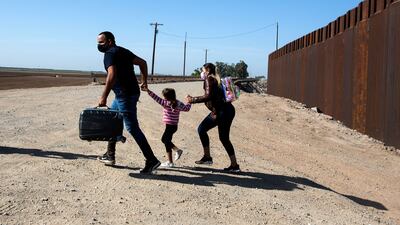 A Cuban family of migrants run across an open section of road at the US-Mexico border in Arizona. AFP