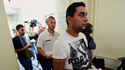 Suspects are led by a Hungarian police official (C) into the Kecskemet courtroom on August 29. Four suspects in the deaths of 71 migrants found in an abandoned truck in Austria arrived on August 29 for a court hearing in Hungary. AFP Photo