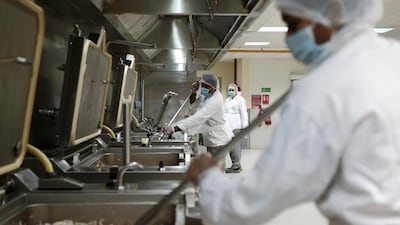 Workers prepare food in the kitchen. The menu rotates monthly. Christopher Pike / The National