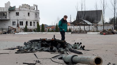 A man examines the debris of a destroyed Russian tank in Bohdanivka. EPA