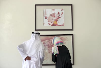 Mr Al Mehairbi with reporter Haneen Dajani looking at a picture of Abu Dhabi in the 1960's. Chris Whiteoak / The National