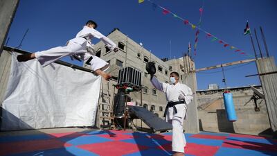 Palestinian Khaled Sheikh el-Eid, a Karate instructor, trains with his son on their home rooftop, amid concerns about the spread of coronavirus, in Rafah in the southern Gaza Strip. Reuters