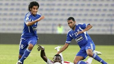 Ibrahim Diaky, centre, tumbles between Ali Abbas, left, and Mahmoud Darwish, right, whose Al Nasr side are unbeaten in six games.