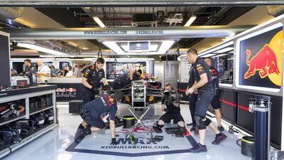Crew members work on Verstappen's car during first practice. Christopher Pike / The National