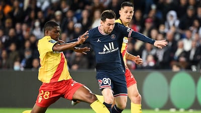 Lionel Messi attempts to ride a challenge from Lens defender Cheick Doucoure. AFP