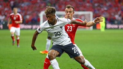 France forward Kingsley Coman, right, cuts in front of Switzerland winger Xherdan Shaqiri. Clive Mason / Getty Images