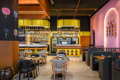 The Art Deco-style central bar is flanked by walls with pastel fans and Hahoetal masks. Photo: Hoe Lee Kow