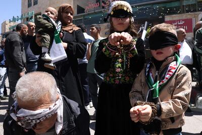 Demonstrators in the West Bank mimic being handcuffed in solidarity with Palestinian prisoners. AFP