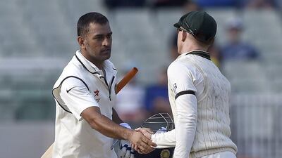 India captain MS Dhoni, left, shakes hands with Australia's Chris Rogers at the end of the final day of the third Test on Tuesday in Melbourne. Andy Brownbill / AP / December 30, 2014