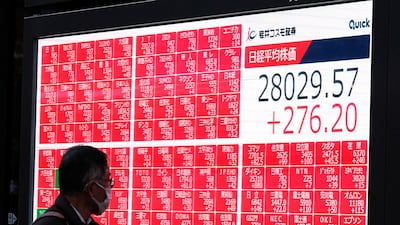 A pedestrian walks past an electronic quotation board displaying the closing share prices of the Tokyo Stock Exchange on Friday in Tokyo. AFP