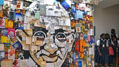 Schoolchildren walk next to a paper mosaic depicting Gandhi at Egmore Museum in Chennai. Martyr's Day is observed as a day of peace and non-violence. EPA