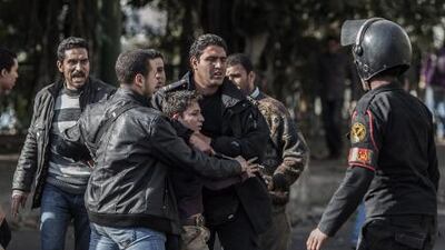 Egyptian security forces detain an anti-government protester during clashes in Cairo on Wednesday. A fight between Egypt's president and the judiciary over elections is likely to heighten tensions in the country. Oliver Weiken / EPA