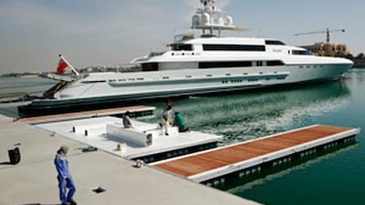 Workers prepare the area at the Abu Dhabi National Exhibition Centre as the 'Silver' is docked in the background.