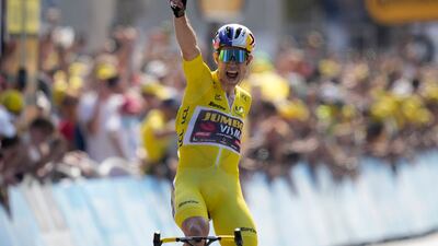 Belgium's Wout Van Aert, wearing the race leader's yellow jersey, celebrates as he crosses the finish line to win Stage 4 of the Tour de France on Tuesday, July 5, 2022. AP