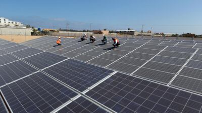 Workers install solar panels at the Khan Younis Waste Water Treatment Plant in southern Gaza. Reuters