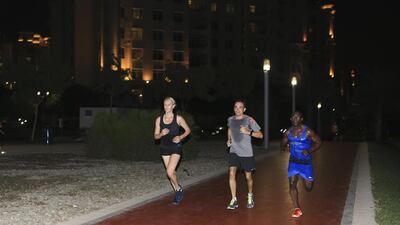 From left, Nike Run Club runners Ea Wederwang, Nicolas Lemaitre and coach Rafael Roots run along the track in Al Ittihad Park on the Palm Jumeirah, Dubai, this week. Sarah Dea / The National