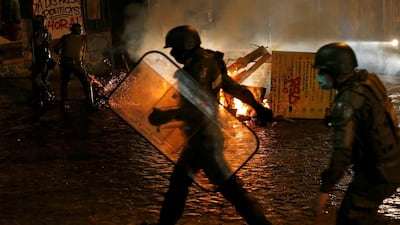 Security forces are seen near a burning barricade during a protest against the Pension Funds Administration after a congressional session on a pensions reform in Valparaiso, Chile. Reuters
