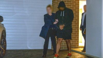 A person is detained by Australian Federal Police after Operation Ironside raids against organised crime. Reuters.