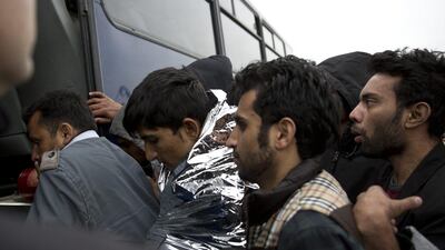 Syrian men get in a bus to Moria camp after 127 refugees and migrants were rescued by the Greek coast guard on March 22. Petros Giannakouris / AP
