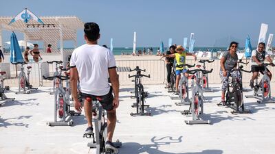 Sun-seekers got on their bikes to get in the holiday mood at a Dubai Fitness Challenge spin class at Kite Beach. Antonie Robertson/The National