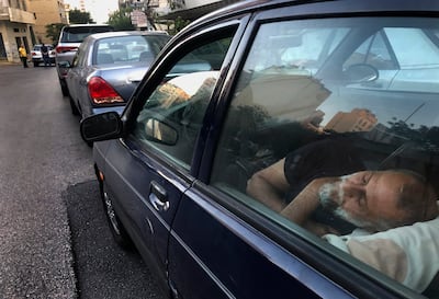 A taxi driver sleeps inside his car as he waits in a long queue for fuel in the Lebanese capital, Beirut. AP