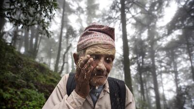 An elderly pilgrim ritually applies corn flour in his face while trekking. Narendra Shrestha/EPA