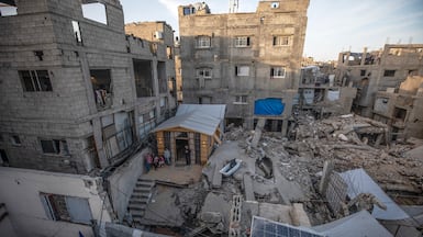 Construction worker Alaa Jouda and his family stand outside the temporary shelter he has built on the ruins of his home in Al Shati refugee camp in Gaza city. EPA