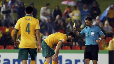 Australia's Mile Jedinak, second left, is shown a yellow as he hovers over UAE's Omar Abdulrahman during Tuesday's Asian Cup semi-final. Edgar Su / Reuters