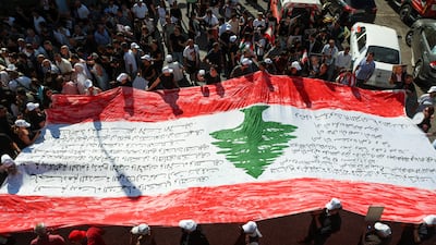 People gather around the Lebanese flag during a march in Beirut as Lebanon marks the three-year anniversary of the August 4, 2020, port explosion. Reuters