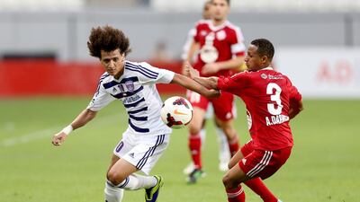 Al Ain's Omar Abdulrahman, left, fights off a Sharjah challenge during their match on Tuesday. Mostafa Reda / Al Ittihad
