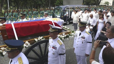 Ferdinand Marcos’ flag-draped casket is carried by horse-drawn carriage with a military escort through Taguig, Philippines, on November 18, 2016, on its way for internment in the Cemetery of Heroes, followed by the ex-dictator’s wheelchair-bound wife Imelda, 87, and their children and grandchildren. Office of Ilocos Norte Governor Imee Marcos via AP