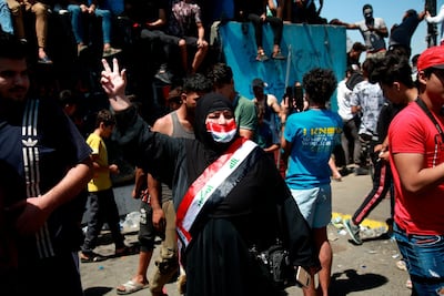 A woman flashes the victory sign during ongoing anti-government protests in Baghdad. AP Photo
